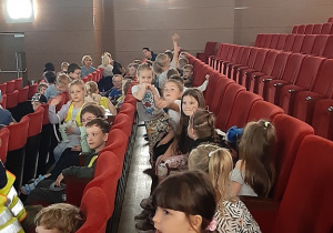 Dzieci czekają na widowni na przedstawienie.